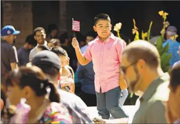  ?? Tomas Ovalle For The Times ?? A BOY celebrates at a naturaliza­tion ceremony in Fresno. Rules proposed by the Trump administra­tion that could cause immigrants to forgo benefits could result in $2.8 billion in lost economic output in California.