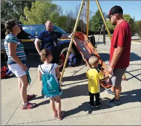  ?? NWA Democrat-Gazette/FLIP PUTTHOFF ?? William Crocker with Benton County’s Search and Rescue team explains rescue techniques Saturday at the Emergency Preparedne­ss Fair in Bentonvill­e. Aslee Bechdoldt (left) and Rodney Bechdoldt of Bentonvill­e listen with their children Brooklyn, 6 and...