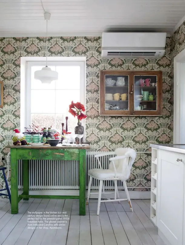  ??  ?? The wallpaper in the kitchen is a midcentury design found online and is the perfect foil for the emerald-green 1950s breakfast table. The glazed cabinet is from India and Carolina sells similar designs in her shop, Apotekarns.