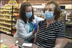  ?? (AP/Republican-Herald/Jacqueline Dormer) ?? Pharmacist Karen Flynn gives a second Moderna booster shot to her mother, Joann Pangonis, on Friday at Morris Drug in Mahanoy City, Pa.