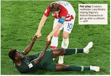  ?? — AFP ?? Fair play: Croatia’s midfielder Luka Modric helping Nigeria’s Kelechi Iheanacho to get up after a collision.