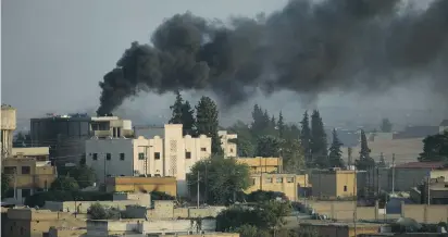  ?? (Stoyan Nenov/Reuters) ?? SMOKE RISES above the Syrian town of Tel Abyad in October 2019 as Turkish forces bombarded it.