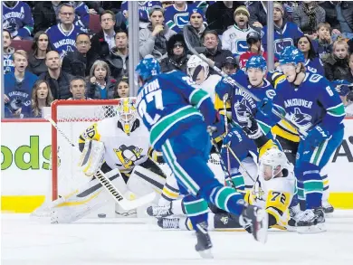  ?? DARRYL DYCK, THE CANADIAN PRESS ?? Canucks’ Ben Hutton has his shot blocked by a sliding Patric Hornqvist, of Pittsburgh, in front of goalie Matt Murray.