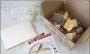  ?? HONS—ASSOCIATED PRESS ?? This image released by Murray’s Cheese shows a box filled with cheeses and other pairings by a laptop for a virtual class about cheese.