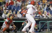  ?? AP Photo ?? The Phillies’ Ryan Howard, right, follows through after hitting a sacrifice fly off Nationals starting pitcher Ross Detwiler in the fourth inning Tuesday in Philadelph­ia.