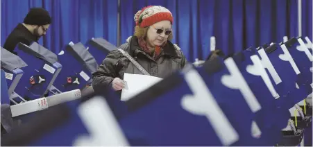  ?? AP FILE PHOTO ?? HACKER THREATS: Chicago resident Sonja Russell walks up to a voting machine to cast her ballot last week.