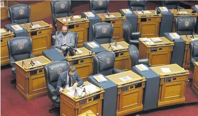  ??  ?? State Sen. Steve Fenberg, D-Boulder, front, and Sen. Robert Rodriguez, D-Denver, sit amid the empty desks before the chamber reopens Tuesday in Denver. Lawmakers reconvened the 2020 session, which was suspended to deal with the new coronaviru­s in March, facing the prospect of making deep cuts in the budget.