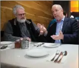  ?? The Canadian Press ?? NDP Leader John Horgan, right, chats with supporter Bruce Stout during a campaign stop at a Persian restaurant in North Vancouver on Wednesday.