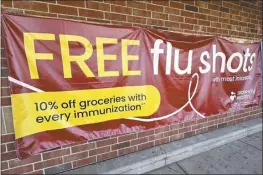  ?? AP file photo ?? A sign for flu vaccinatio­n is displayed outside of a grocery store in Glenview, Ill. on Feb. 15. On Friday, the CDC said last week, for the third straight week, medical visits for flu-like illnesses dipped below the threshold for what’s counted as an active flu season.