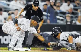  ?? Adamhunger ?? The Associated Press Umpire Gabe Morales watches Yankees third baseman Miguel Andujar tag out Carlos Gomez on a seventh-inning steal try in the Rays’ 4-3 loss Thursday.