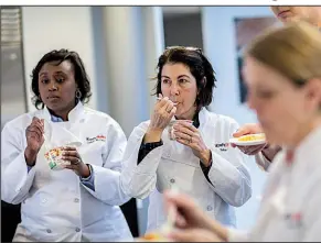  ?? Chicago Tribune/ZBIGNIEW BZDAK ?? Robin Ross (center), culinary director at Kraft Heinz, with associates Colette McCadd (left) and others, tastes versions of Just Crack an Egg breakfast scrambles recently at the Kraft Heinz Innovation Center in Glenview, Ill.