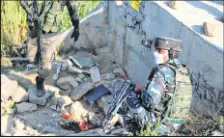  ??  ?? Security men inspect the attack site in Srinagar on Monday.