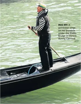  ?? AFP ?? MIO MY:
A gondolier sings on his gondola under the Rialto Bridge in Venice during Carnival