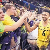  ?? CHRIS PIETSCH/ASSOCIATED PRESS ?? Oregon’s Tyler Dorsey, right, celebrates with fans after the Ducks upset top-seeded Kansas on Saturday to earn a berth in next week’s Final Four in Arizona.