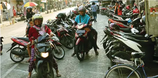  ?? CHUSNUL CAHYADI/JAWA POS ?? DAERAH RAMAI: Parkir sepeda motor di depan Pasar Gresik di Jalan H Samanhudi kemarin. Kawasan ini bakal menjadi tempat uji coba parkir nontunai.