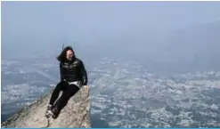  ??  ?? A woman posing on a rock for photos on Hong Kong’s highest peak Tai Mo Shan.