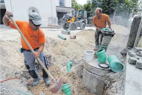  ?? FOTOS: SEBASTIAN KORINTH ?? Mitarbeite­r der Firma Hahn aus Stetten am kalten Markt bereiten den Vorplatz für die neuen Betonstein­e vor.