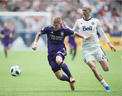  ?? — CP PHOTO ?? Orlando City’s Chris Mueller, left, is watched closely by Vancouver’s Brek Shea, who started at left back for the second straight game, this one a convincing 5-2 Whitecaps victory at B.C. Place Stadium Saturday.