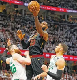  ?? THE ASSOCIATED PRESS ?? The Cleveland Cavaliers’ LeBron James, center, drives to the basket against the Boston Celtics’ Aron Baynes, left, and Jayson Tatum in the first half of Game 6 of the NBA Eastern Conference finals Friday in Cleveland. The Cavaliers won 109-99.