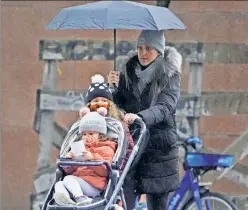  ?? ?? Mask up and bundle up: A maskless Manhattan mom takes her children to school, where they might be forced to eat lunch outside for “safety’s sake.”