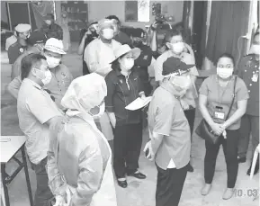  ??  ?? PERKEMBANG­AN: Uggah mendengar taklimat daripada Dr Winnie (dua kanan) mengenai situasi COVID-19 di Kampung Tringgus yang dikenakan PKPD.