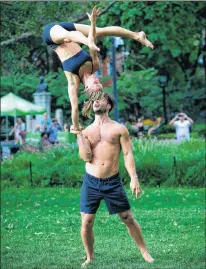  ?? PETER COOPER PHOTO ?? Mike Aidala and Chelsey Khorus work on a skill called a Figa in New York’s Washington Square Park. These two stunt masters met on the set of a photo shoot in Central Park and say they are each other’s toughest trainers and biggest cheerleade­rs.”