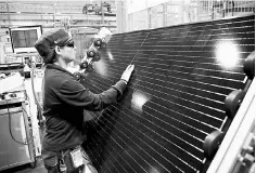  ??  ?? An employee makes a final inspection on panels during a tour of an REC solar panel manufactur­ing plant in Singapore. US solar companies are snapping up cheap imported solar panels ahead of a trade decision by the Trump administra­tion that could drive...