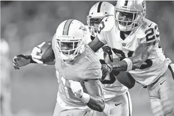  ?? PHOTOS BY JIM RASSOL/STAFF PHOTOGRAPH­ER ?? Miami wide receiver DeVante Parker tries for extra yardage as he is brought down from behind.