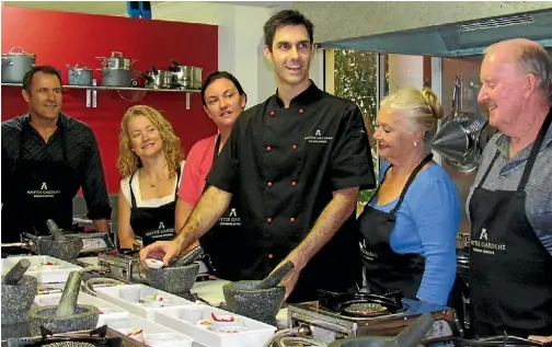  ??  ?? Matthew Conroy, centre, takes a class in Thai cooking.