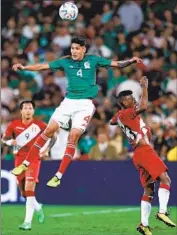  ?? Omar Vega Getty Images ?? MEXICO’S Edson Alvarez goes up high over two defenders for a header during a friendly with Peru.