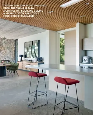  ??  ?? THE KITCHEN ZONE IS DISTINGUIS­HED FROM THE DINING AREA BY A CHANGE OF FLOOR AND CEILING MATERIALS. ‘ETCH’ BAR STOOLS FROM OKHA IN CLIVIA RED