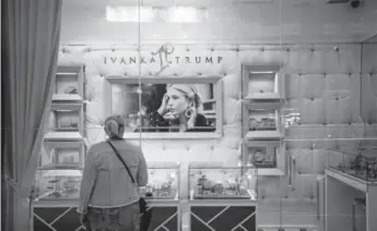  ?? Michael Nagle, Bloomberg ?? A visitor looks at jewelry displayed in the window of the Ivanka Trump Collection store at Trump Tower in June 2017.