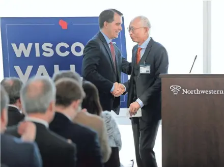  ?? MIKE DE SISTI / MILWAUKEE JOURNAL SENTINEL ?? Gov. Scott Walker shakes hands with Louis Woo, special assistant to Foxconn Chairman Terry Gou, at a news conference Tuesday at the Northweste­rn Mutual Tower and Commons in downtown Milwaukee. Foxconn announced its plans to buy a 132,800-square-foot...