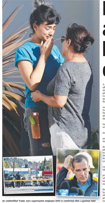  ?? An unidentifi­ed Trader Joe's supermarke­t employee ee ( left) is comforted after a gunman held hostages inside the store in Los Angeles on Saturday. Police believe a man involved in a standoff at the Los Angeles supermarke­t shot his grandmothe­r and girlfri ??