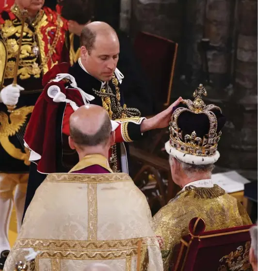  ?? ?? ► El príncipe Guillermo de Gran Bretaña toca la corona de San Eduardo en la cabeza del rey Carlos III.