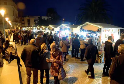  ??  ?? Mercatini A sinistra la gente in via Venezia, sulla Muraglia, dove è stato allestito un mercatino di Natale: in basso la ruota panoramica sul lungomare, grande attrazione di queste feste