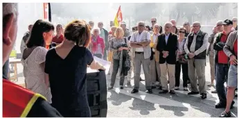  ??  ?? À gauche et de dos, Aurélie Caro prononce son discours devant le public rassemblé devant l’entrée de la gare SNCF.