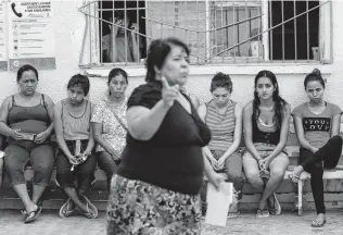  ?? Photos by Gregory Bull / Associated Press ?? Marta Alicia Esquivel, a volunteer at El Buen Pastor shelter for migrants, center, scolds a group of mothers about the care of their children and asks for more help with cleaning the shelter.