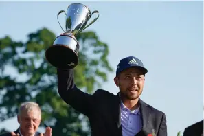  ?? The Associated Press ?? ■ Xander Schauffele celebrates with the trophy after winning the Travelers Championsh­ip at TPC River Highlands June 26 in Cromwell, Conn.