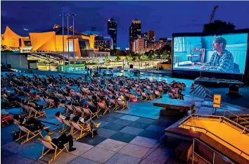  ?? — AFP ?? Movie-goers watch Danish Oscar-winning movie “Druk” (Another Round) featuring Danish actor Mads Mikkelsen (on screen) at a temporary open air cinema in Berlin’s Kulturforu­m (Culture Forum) area, as restrictio­ns were eased amid the novel Covid-19 pandemic.