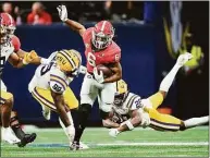  ?? John Bazemore / Associated Press ?? Georgia running back Kenny McIntosh (6) tries to escape from LSU safety Major Burns (28) and defensive tackle Jaquelin Roy (99) in the second half of the Southeaste­rn Conference Championsh­ip game Saturday in Atlanta.