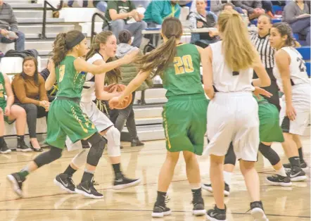  ?? NICK SANCHEZ/THE NEW MEXICAN ?? Desert Academy’s Olivia Ragitti faces a wall of Pecos defenders on Thursday in Santa Fe. The school has struggled to field a girls’ basketball team, and this year, joined forces with players from Santa Fe Waldorf to field a team dubbed the Wild Wolves....