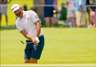  ?? Matt York / Associated Press ?? Dustin Johnson chips on the first hole of a practice round for the PGA Championsh­ip. Johnson is seeking confidence in his driver, which will be important at Southern Hills.