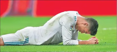  ?? SERGIO PEREZ /REUTERS ?? A dejected Cristiano Ronaldo lies on the turf after Real Madrid’s 1-0 La Liga loss to Real Betis at Santiago Bernabeu Stadium on Wednesday. The loss left Ronaldo’s side seven points back of league leader Barcelona.