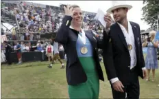  ??  ?? Tennis Hall of Fame inductees Kim Clijsters of Belgium and Andy Roddick of the United States laugh as they walk around center court to acknowledg­e fans during enshrineme­nt ceremonies at the Internatio­nal Tennis Hall of Fame on Saturday in Newport, R.I....