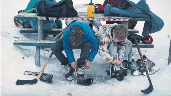  ?? STEVE RUSSELL TORONTO STAR ?? Skaters lace up at the Leslie Grove Park outdoor rink. The natural rink season is now lasting only from early January until late February, with one or two thaws in the middle.