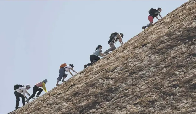  ?? PICTURE: AP ?? 0 A sight that won’t be seen in the future: a group of tourists scale the steep western face towards the summit of Uluru