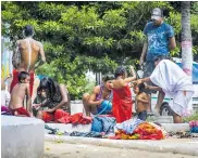  ??  ?? Varios migrantes se bañan en una plaza cercana.