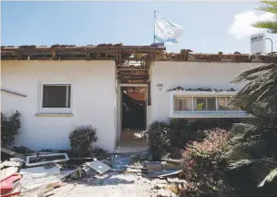  ?? (Amir Cohen/Reuters) ?? A FLAG flutters atop a house in Ashkelon after it was hit by a rocket launched from the Gaza Strip during the recent operation, last month.