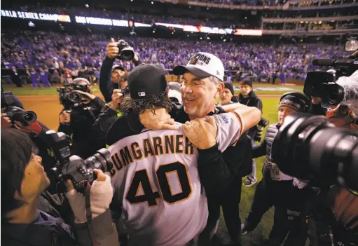  ?? Michael Macor / The Chronicle 2014 ?? Giants pitcher Madison Bumgarner and manager Bruce Bochy embrace after defeating the Royals 3-2 to win Game 7 of the 2014 World Series.